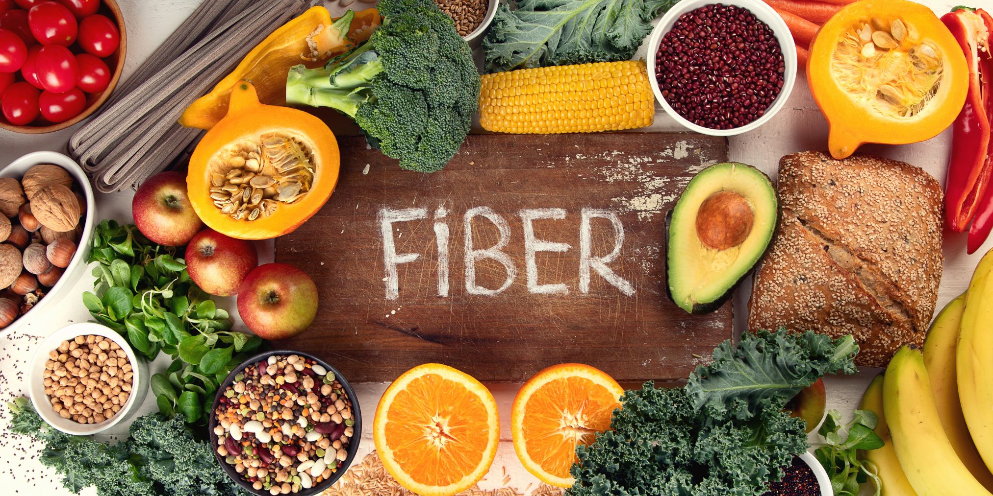 fiber written on a cutting board surrounded by foods high in fiber