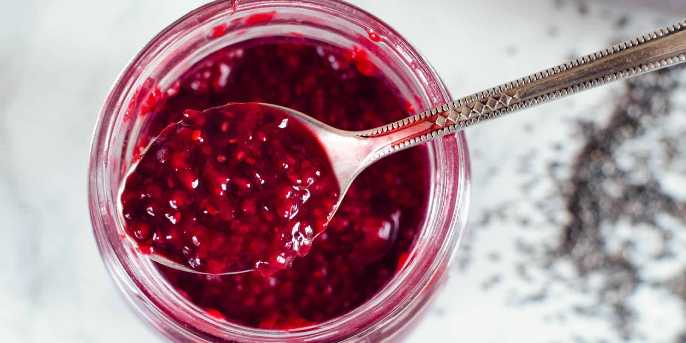 pomegranate jam in a jar with a spoon
