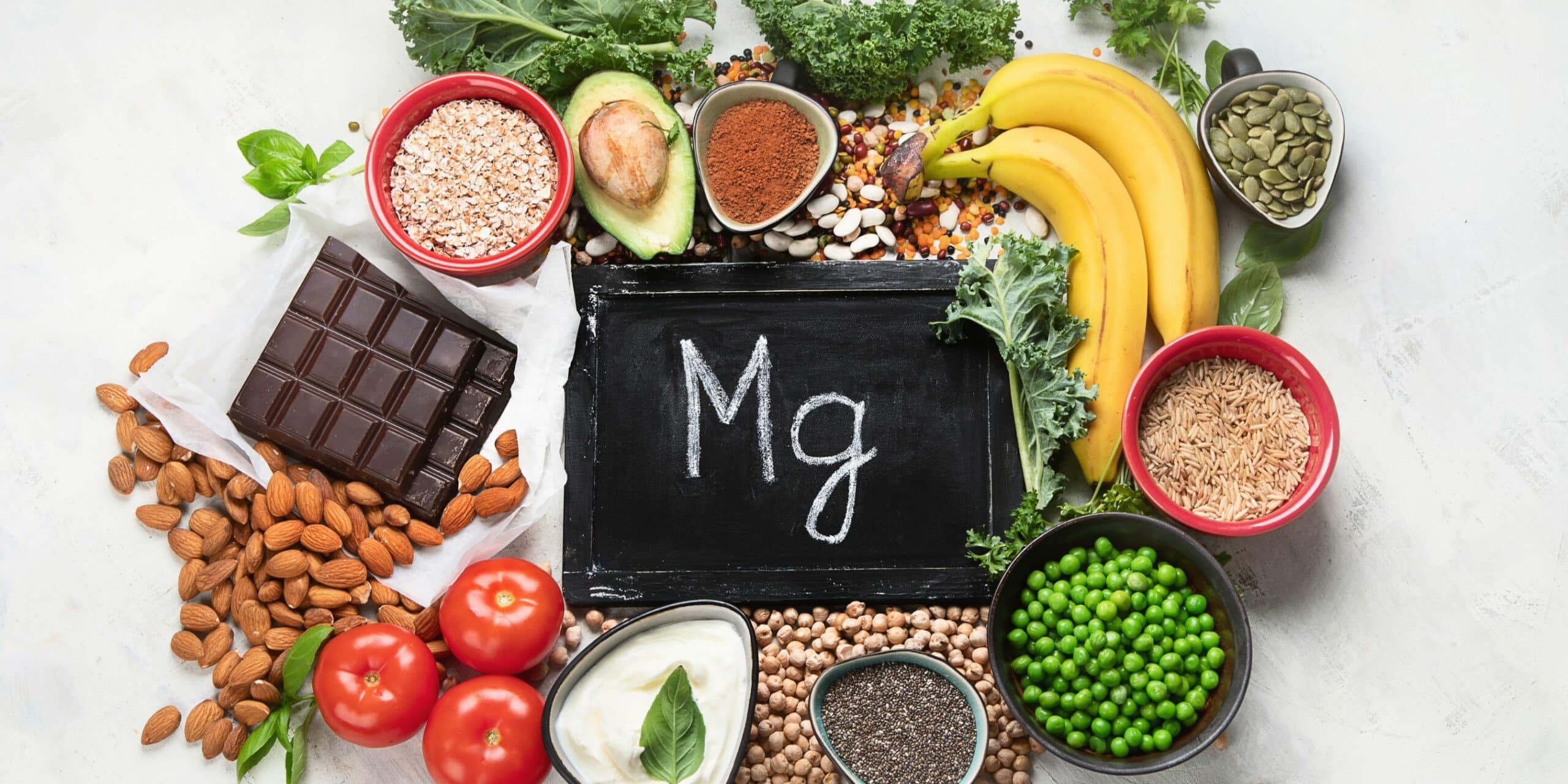 magnesium containing foods around a chalkboard with Mg